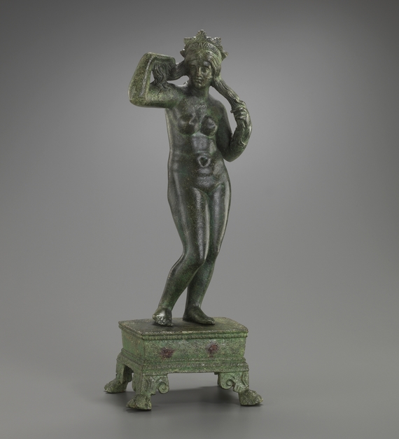 Statuette d'Aphrodite Anadyomène posée sur un petit socle rectangulaire